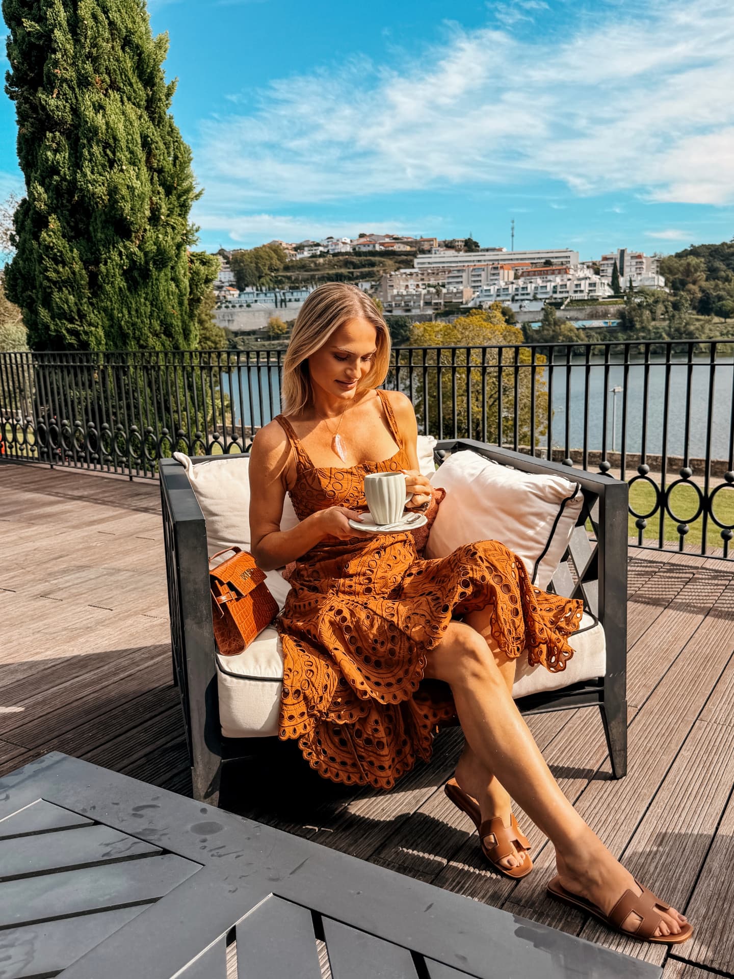 Emilim sentada num terraço com vista para o rio Douro, com o casario da margem oposta ao fundo, no Porto